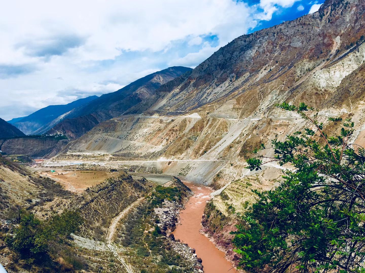 A road winding along a deep gorge above a brown river
