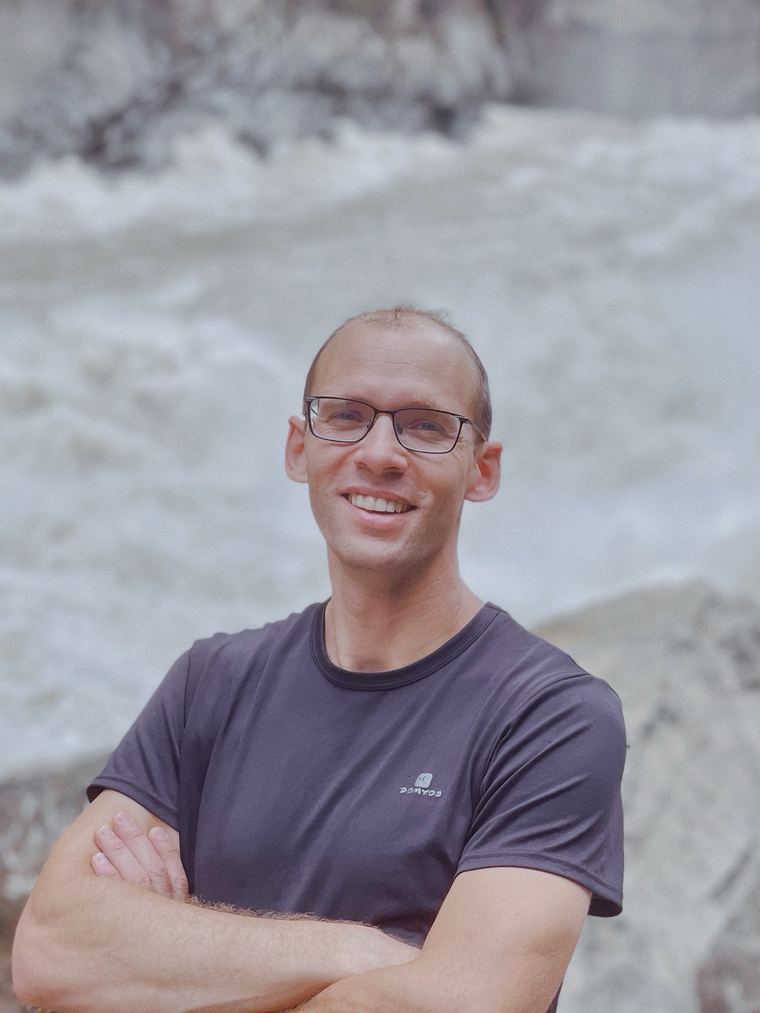 Yannick, smiling, in front of the rapids of the Jinsha River